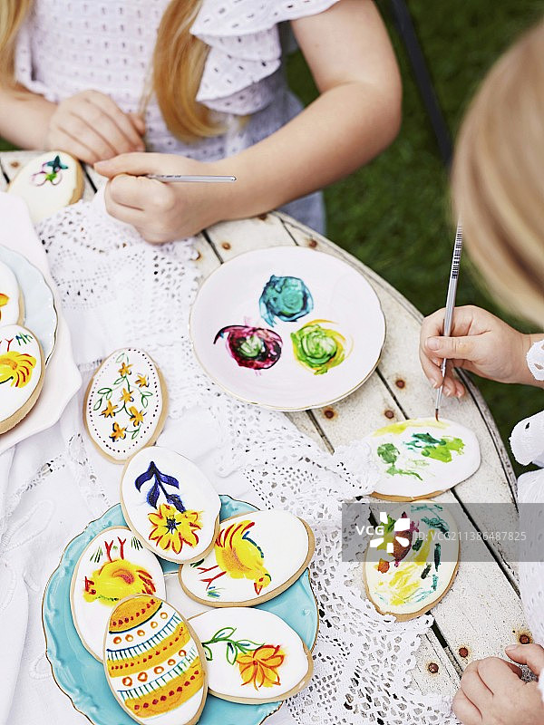 女孩们绘制复活节饼干图片素材