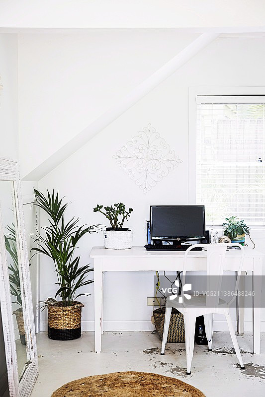 阁楼窗前的白色桌子和经典金属椅子图片素材