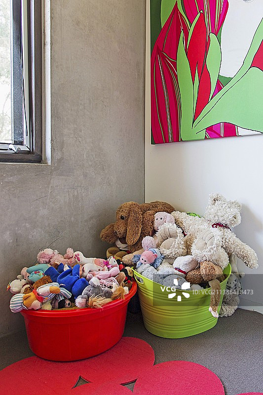 儿童角装满毛绒玩具的彩色塑料桶图片素材