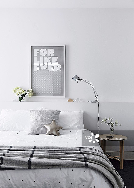 床头带有储物空间的双人床，配有床罩和枕头图片素材