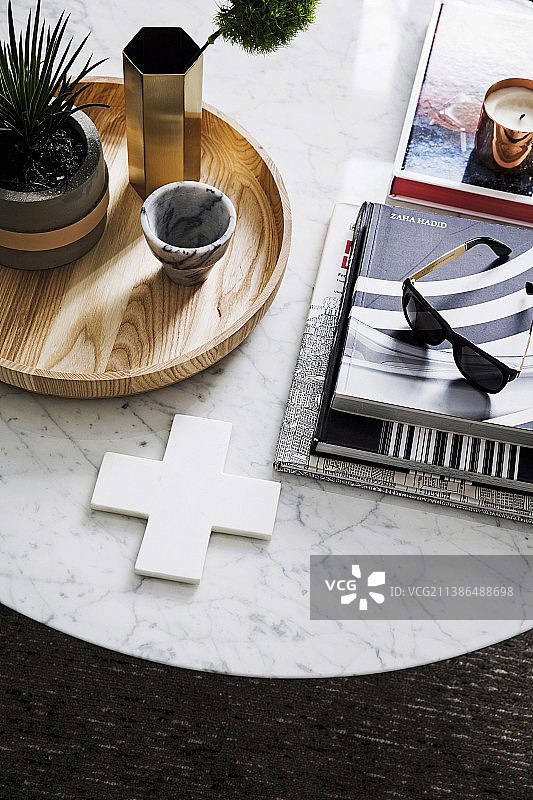 书堆、太阳镜和带绿色植物的木制托盘图片素材