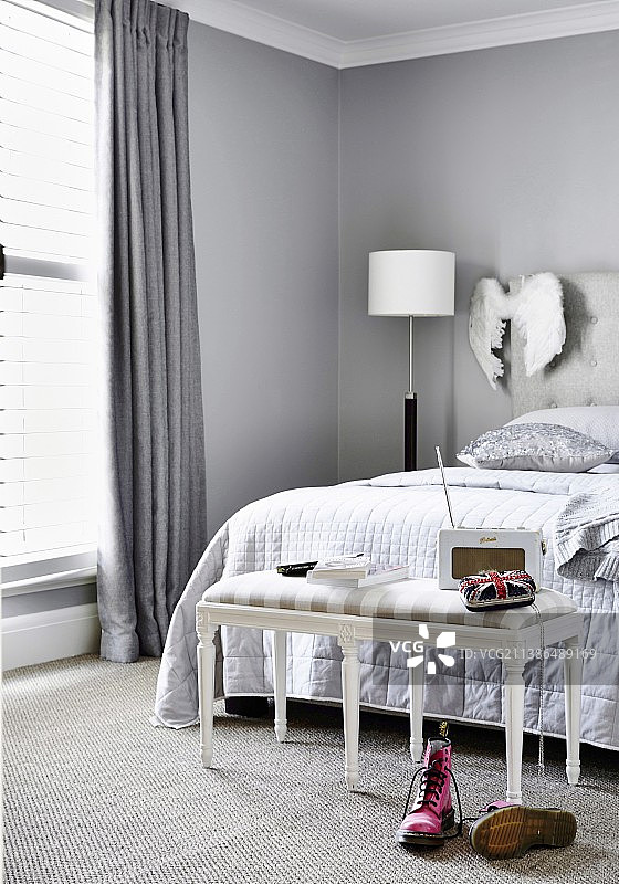 卧室床前的灰色软垫长凳图片素材