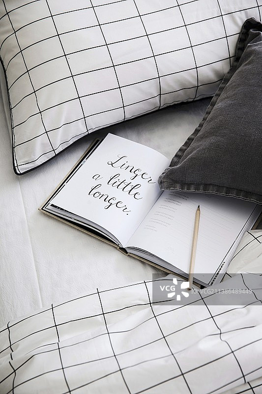 床上的打开的书本，带有图形参考图片素材