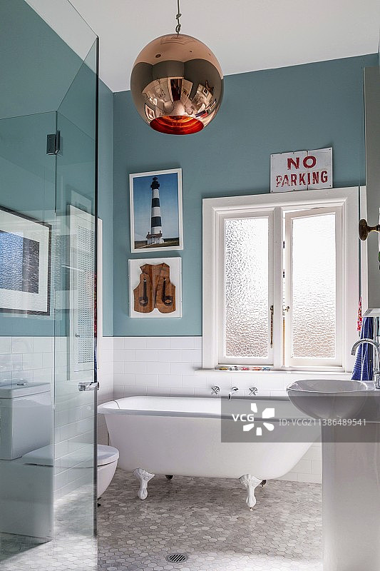 怀旧独立浴缸、蓝绿色墙漆和复古球形灯的浴室；兼收并蓄的风格图片素材