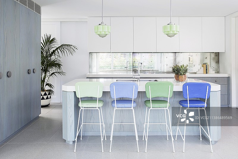 白-灰-蓝色调的简易厨房，厨房岛台上配有蓝色和绿色吧台凳图片素材