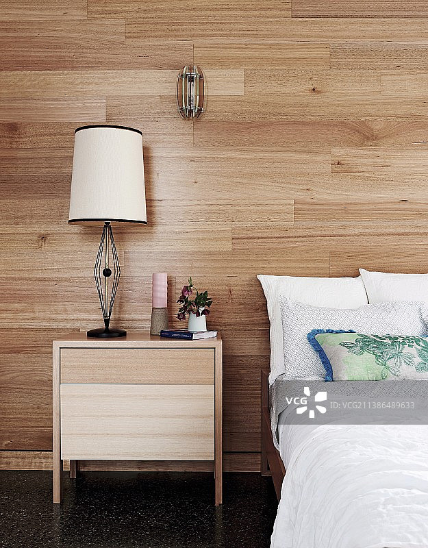 床和简约床头柜，背景为木墙图片素材