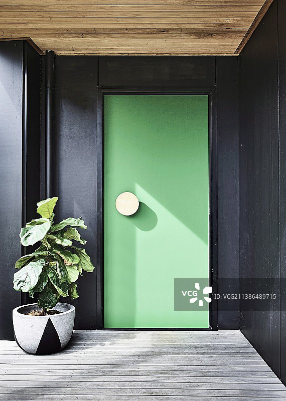 黑色墙壁上的绿色前门图片素材