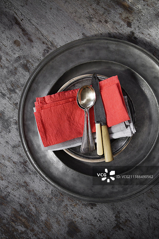 带有角柄的刀具、银勺和锡盘上的餐巾图片素材