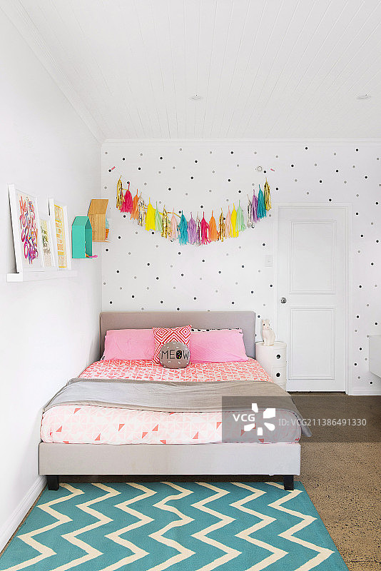 床上的流苏花环，背景是圆点墙图片素材