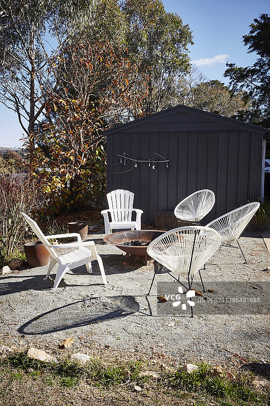 秋季花园露台上火盆周围的白色椅子图片素材