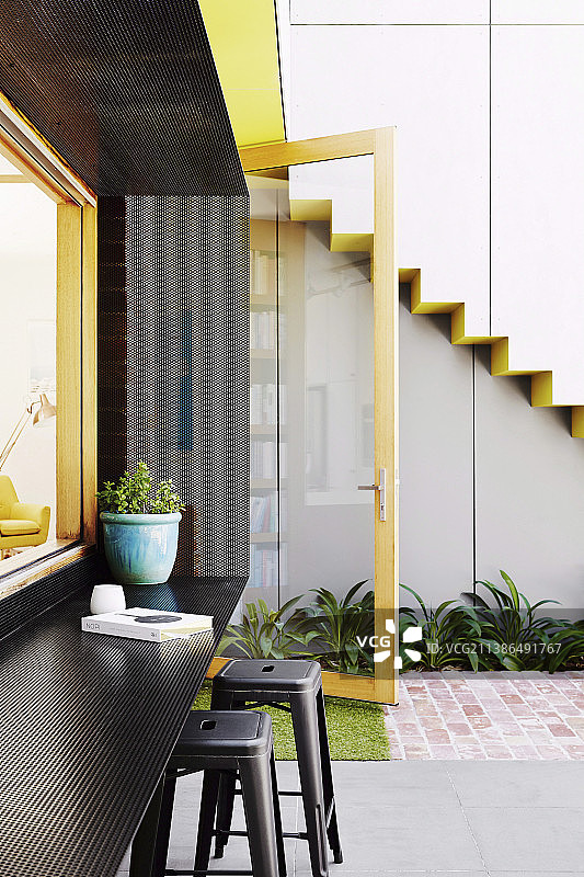 厨房窗户周围环绕着穿孔金属框架，用作遮阳篷和架子图片素材