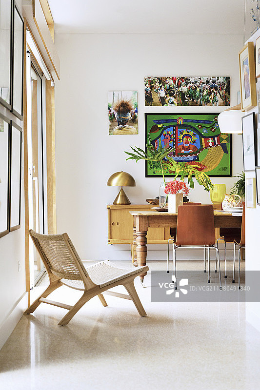 白色地板上旧桌子前方的设计师椅与现代椅子图片素材