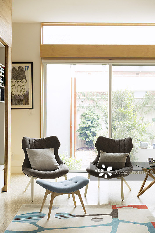 两张灰色扶手椅和蓝色斯堪的纳维亚风格脚凳图片素材