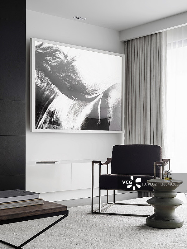 黑白照片墙前的软垫椅和设计师边桌图片素材