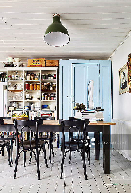 厨房内的餐桌椅、蓝色烤漆橱柜和复古搁板图片素材