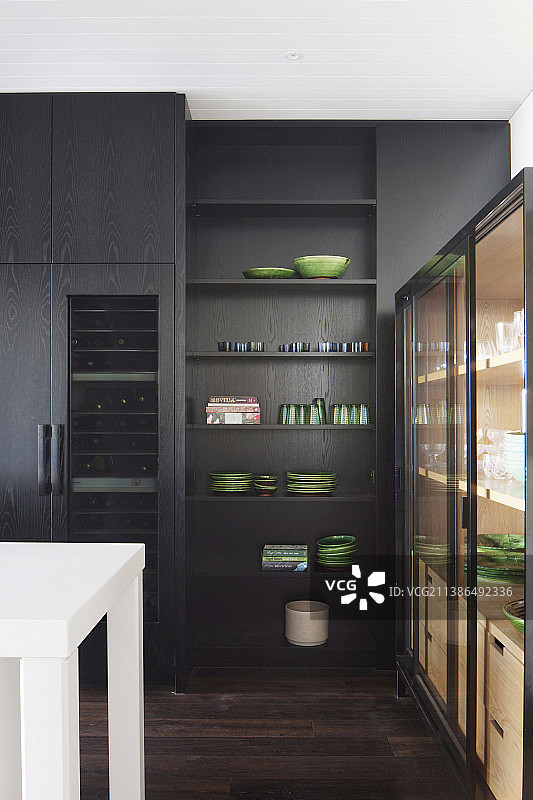 直至天花板的黑色厨房和带有绿色餐具的展示柜图片素材