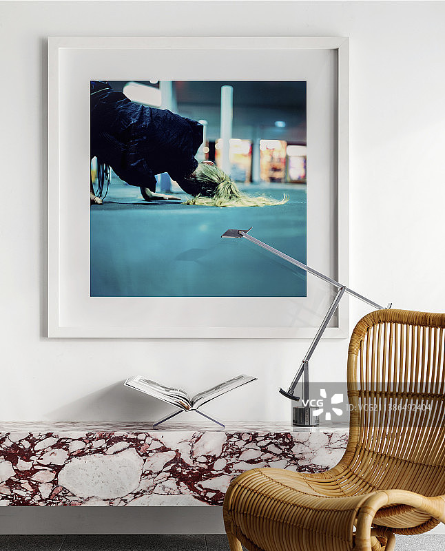 大理石搁板上的设计师灯具，前方的藤椅图片素材