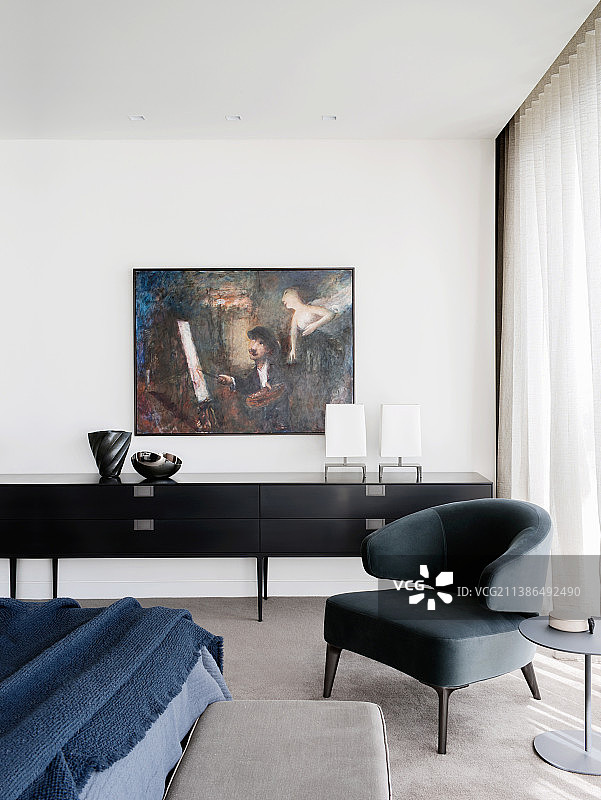 卧室的餐具柜前摆放着设计师扶手椅和边桌图片素材