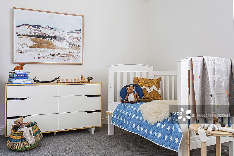 儿童房的床和抽屉柜，以自然色调和蓝色点缀图片素材