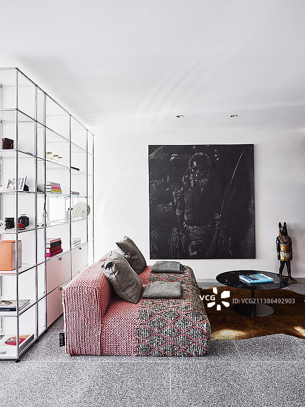 红色设计师沙发、咖啡桌和落地窗前透明搁架图片素材