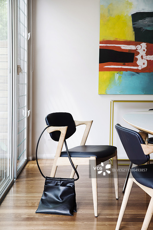 设计师椅子与黑色皮革内饰围绕餐桌图片素材