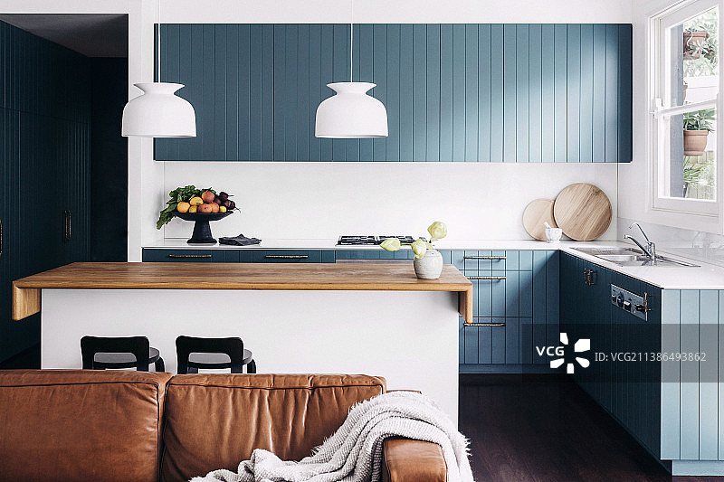 皮沙发与蓝灰色漆木橱柜厨房岛台图片素材
