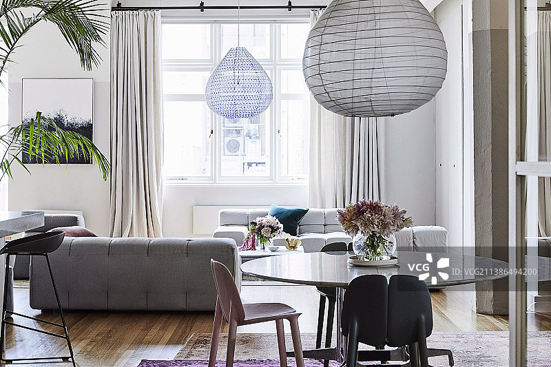 带有圆形餐桌和浅灰色沙发景观的开放式客厅图片素材