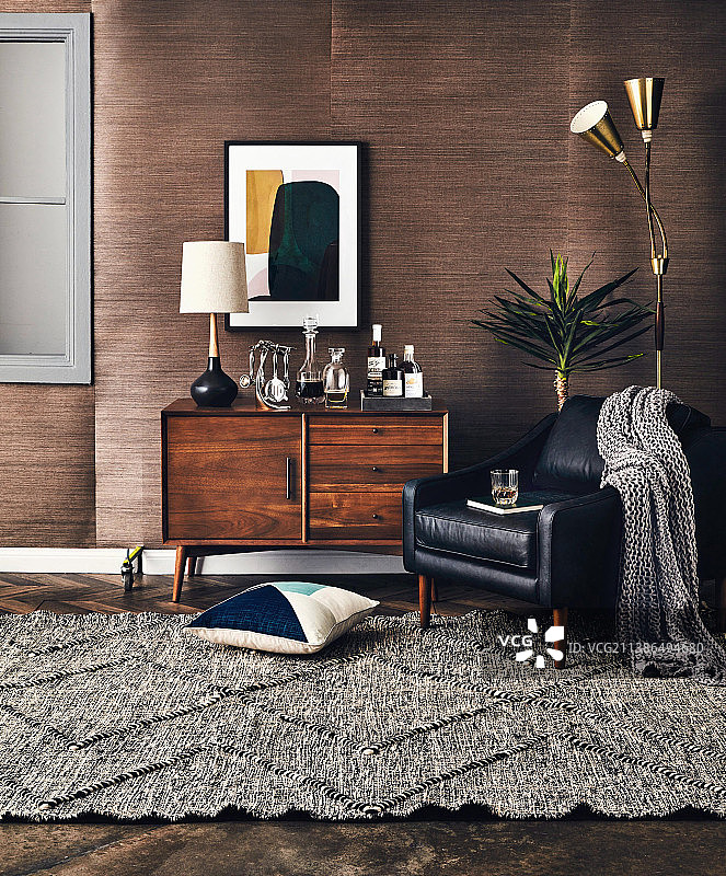 复古餐具柜上的台灯和饮料，带深色木镶板房间内的皮椅和灯图片素材