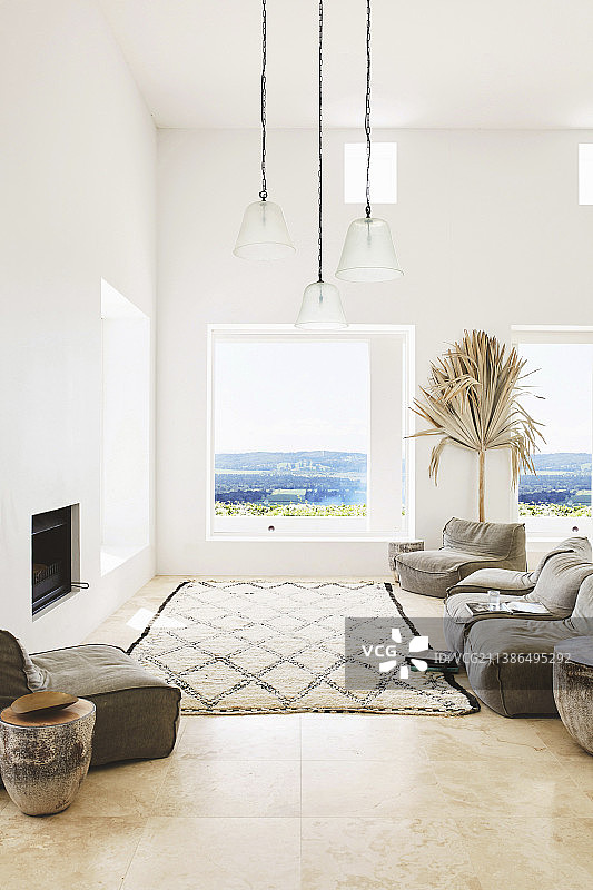 白色海景客厅，壁炉前的软垫家具和地毯图片素材