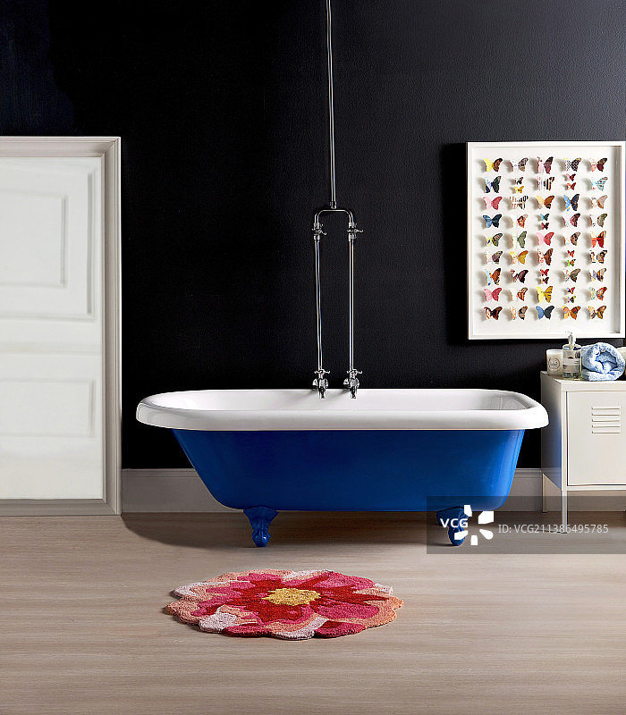 蓝色独立浴缸，黑色背景墙，纸蝴蝶墙面装饰图片素材