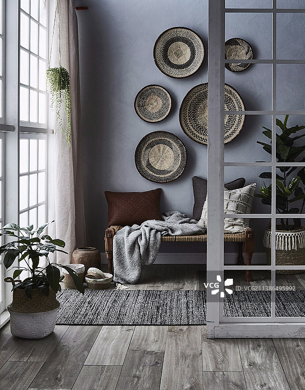 灰色墙壁上长凳与枕头旁的篮子图片素材