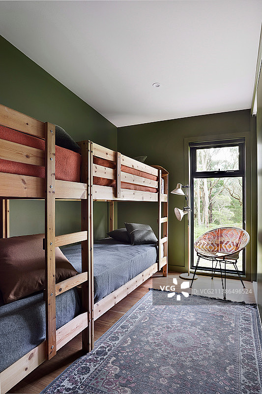绿色墙壁的狭窄房间里的两张双层床图片素材