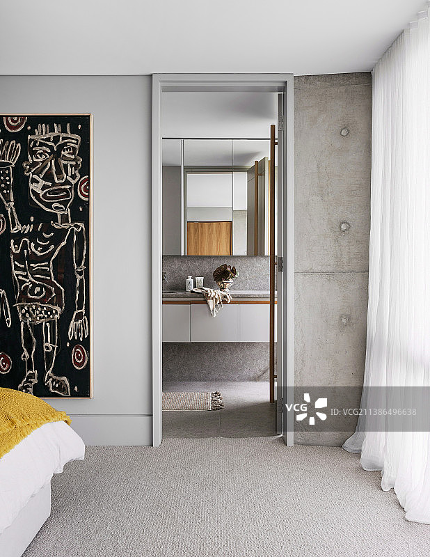卧室视角：混凝土墙通往浴室套间图片素材