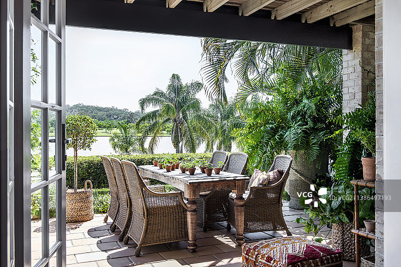 夏季露台上带藤椅的旧木桌图片素材