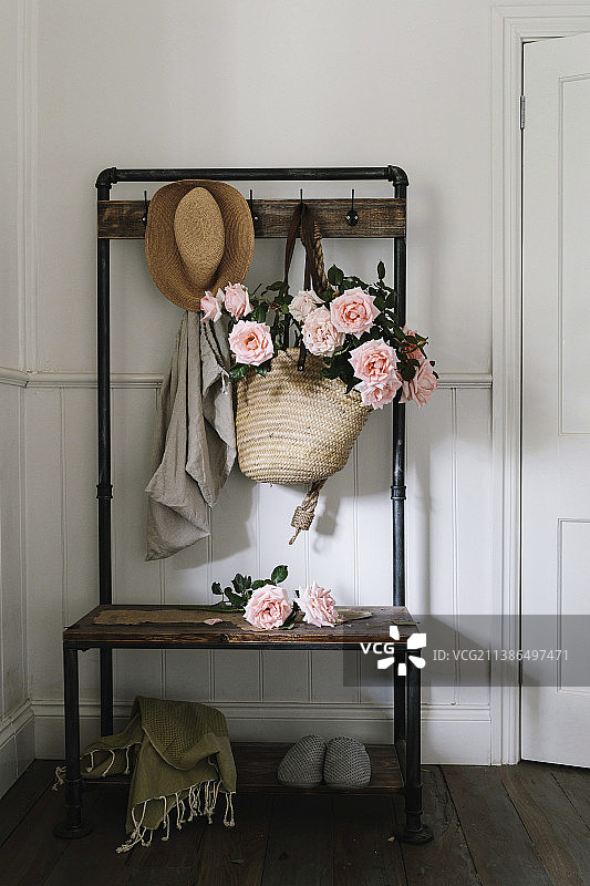 装满茶香玫瑰的篮子包，在复古衣柜上图片素材