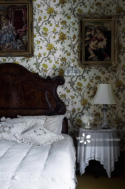 卧室内的乡村风木床、枕头、床头柜和墙纸画作图片素材