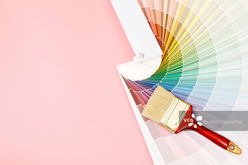 粉色背景上的色板和画笔特写图片素材
