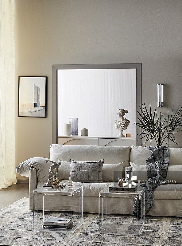 客厅里带浅色罩和枕头的软垫沙发、有机玻璃餐垫图片素材