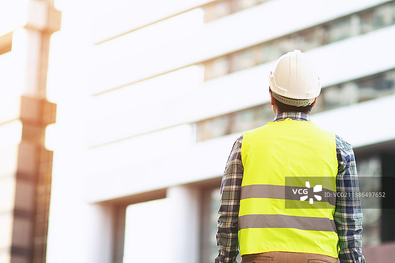 建筑工人手持黄色安全帽图片素材