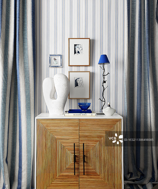 蓝白色条纹窗帘环绕的柜子上的蓝白色装饰品图片素材
