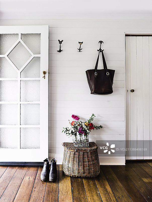 泥房里挂着一个手提袋，上面是从花园里摘的花束和一个渔民的篮子图片素材