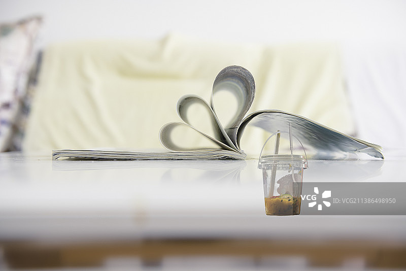 展开的杂志与没有喝完的冷饮图片素材