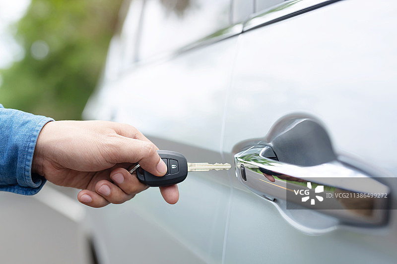 男子手持钥匙插入车门锁图片素材