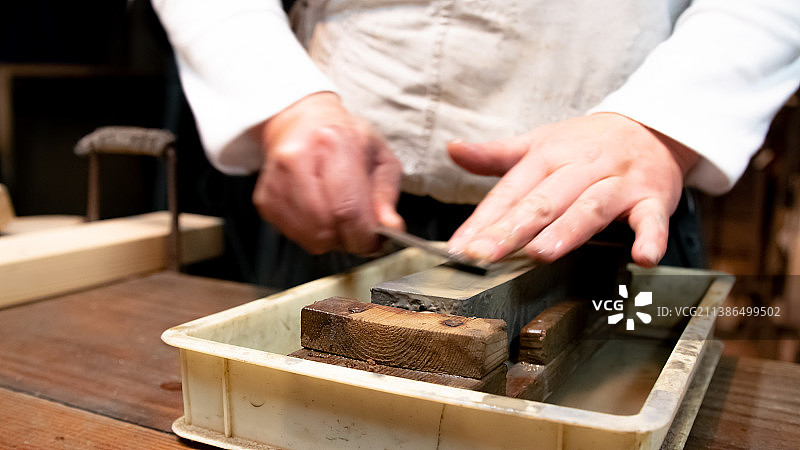日本的铸剑大师在砂轮上用水磨刀图片素材