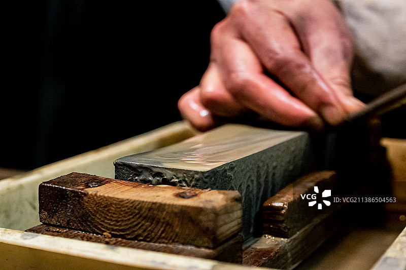 日本的铸剑大师在砂轮上用水磨刀图片素材
