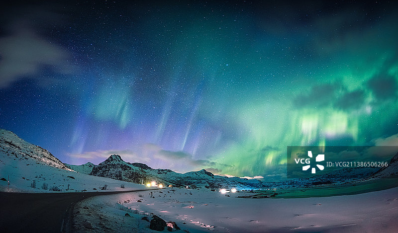 挪威罗弗敦群岛夜空中雪山和海岸线上方绚丽的北极光图片素材