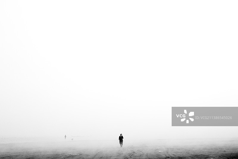 男人在雾天里走在田野上，伊朗吉兰省图片素材