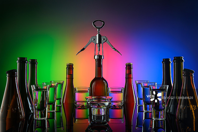 桌上啤酒和葡萄酒瓶特写，彩色灯光背景图片素材