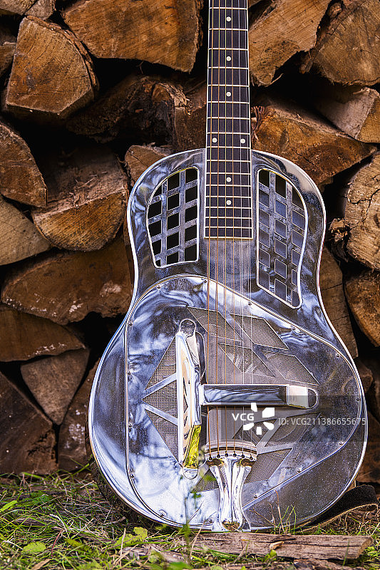 练习木工，吉他靠在木柴堆上图片素材