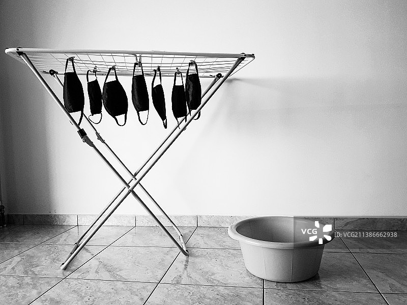 晾衣架上晾晒的带有新冠口罩的衣物图片素材